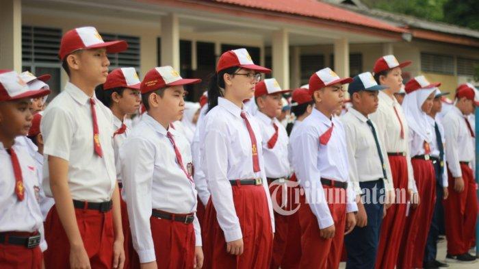 SISWA BARU SMP - Potret siswa baru yang masih mengenakan seragam SD, masuk di SMP Negeri 2 Singkep, Kabupaten Lingga, Provinsi Kepulauan Riau, mengikuti upacara dan pembukaan MPLS, Senin (14/7/2025).