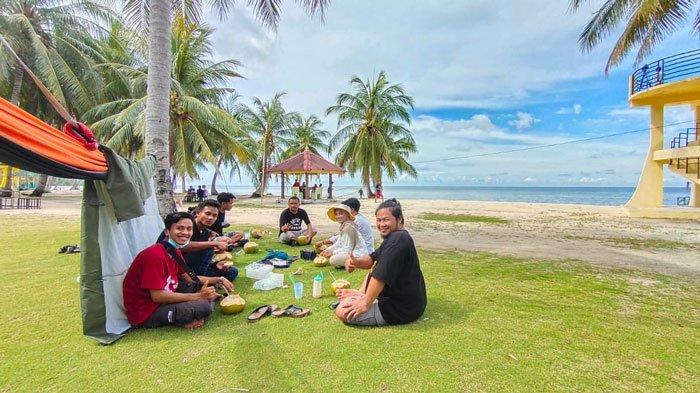 PULAU BENAN - Pengunjung yang menikmati air kelapa muda di area pantai wisata di Lingga, Pulau Benan, Kecamatan Katang Bidare, Kammis (17/6).