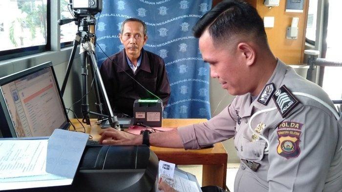 Anggota Ditlantas Polda Sumsel yang ada di Mobil SIM Keliling saat melayani masyarakat yang akan memperpanjang SIM nya di Kolam Retensi Simpang Polda.