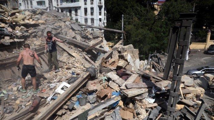 Para pekerja membersihkan puing-puing di tengah Odesa pada 24 Juli 2023, sehari setelah serangan militer, di tengah invasi Rusia ke Ukraina.