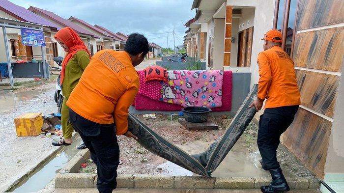 Petugas BPBD Belitung membantu membersihkan rumah warga Perumahan AS Regency, Desa Air Saga, Kabupaten Belitung, yang kebanjiran pada Jumat (1/12/2023).