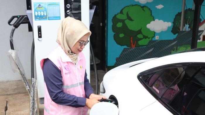 Estuning Rahayu ketika membantu mengisi daya kendaraan listrik milik pelanggan pada periode arus balik mudik lebaran 1446 H.