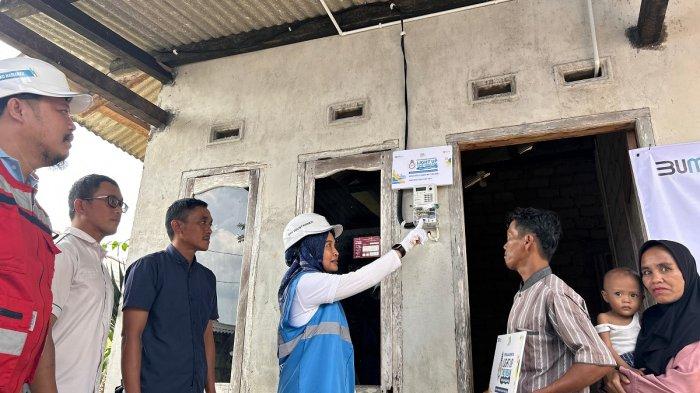General Manager PLN UIW Babel, Dini Sulistyawati (rompi biru tiga dari kanan) melakukan penyalaan perdana penerima manfaat LUTD Bapak Sobirin didampingi perangkat Desa Cambai Selatan dan Manajemen PLN UIW Babel
