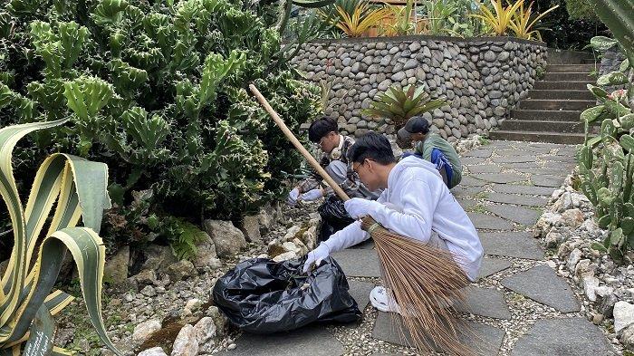 MEMBERSIHKAN SAMPAH - Pelaku vandalisme di Tanaman Kaktus KRB disanksi pengelola pada Senin (21/4/2025).