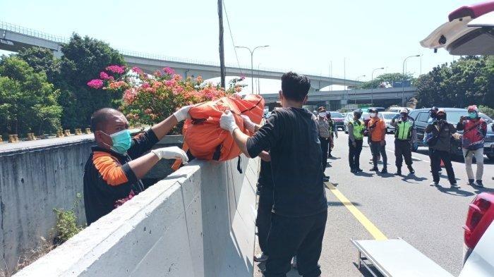 Proses evakuasi jasad pria yang ditemukan di celah beton pembatas jalan Tol Jagorawi KM 7, Cipayung, Jakarta Timur, Rabu (19/7/2023).