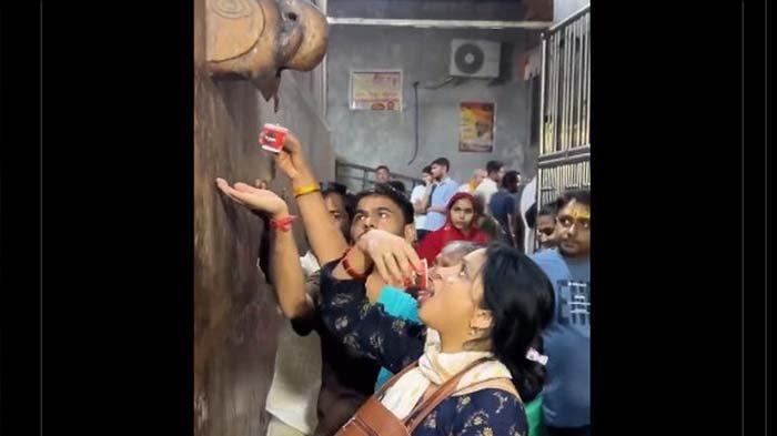 VIRAL AIR AJAIB: Tangkapan layar warga India meminum air tetesan dari patung gajah di kuil dikira air suci ternyata dari air AC. Kasusnya disebut mirip mata air ajaib di Pekalongan yang ternyata berasal dari PDAM bocor, disadur pada Senin (21/4/2025).