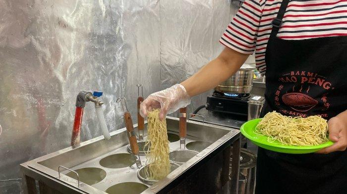KULINER BOGOR - Konsep open kitchen yang ada di outlet Bakmi Hao Peng 111 membuat pembeli bisa melihat langsung proses memasaknya. Proses memasak di sini memastikan setiap sajian memiliki tekstur kenyal dan cita rasa khas yang selalu konsisten.