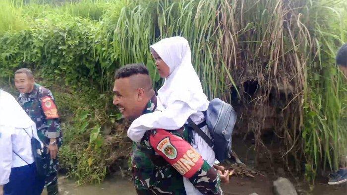 GENDONG PELAJAR - Tangkapan layar video pelajar mendapat bantuan dari petugas TNI Polri melintas daerah aliran sungai karena tidak ada jembatan di Desa Cipedes, Ciniru, Kuningan.