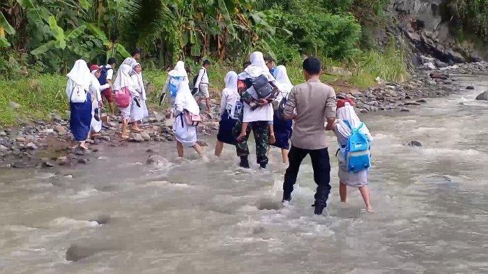 BANTU PELAJAR - Tangkapan layar video pelajar mendapat bantuan dari personel TNI Polri untuk melintas daerah aliran sungai karena tidak ada jembatan di Desa Cipedes, Ciniru, Kuningan.