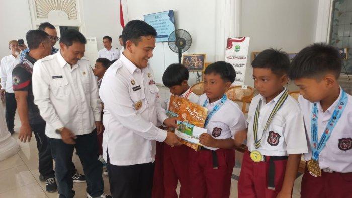 Penjabat Bupati Majalengka, Dedi Supandi, saat menyerahkan penghargaan kepada pesepak bola SSB Vinex-D Cikijing di Pendopo Bupati Majalengka, Jalan Ahmad Yani, Kecamatan/Kabupaten Majalengka, Jumat (18/10/2024)