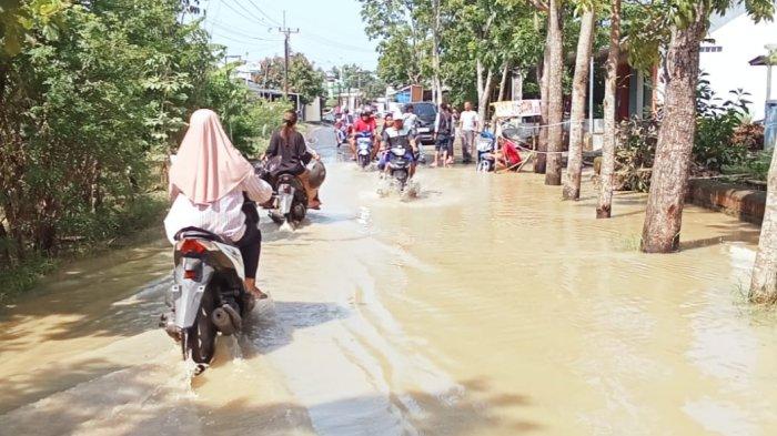 Sejumlah warga berjalan kaki menerjang banjir di Desa Leuweunghapit, Kecamatan Ligung, Kabupaten Majalengka, Selasa (7/1/2025)