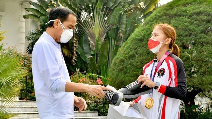 Presiden Jokowi mencoba sepatu sneaker produksi Greysia Polii di Istana Negara, Jumat (13/8/2021).