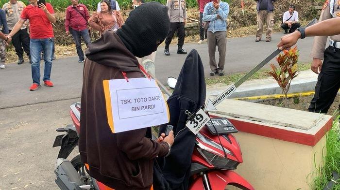 Tersangka TD saat memeragakan adegan hendak membawa kabur sepeda motor korban dalam rekonstruksi pembunuhan pegawai bank keliling di SDN Simpeureum II, Kecamatan Cigasong, Kabupaten Majalengka, Kamis (8/2/2024).