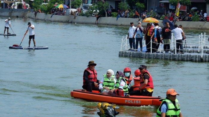 Wakil Ketua DPRD Kota Depoo Fraksi Partai Gerindra Yeti Wulandari (jilbab putih) menggunakan perahu karet milik kepolisian saat menyaksikan langsung Festival Perahu Naga Kota Depok 2022 di Situ Rawa Kalong, Cimanggis, Sabtu (3/12/2022).