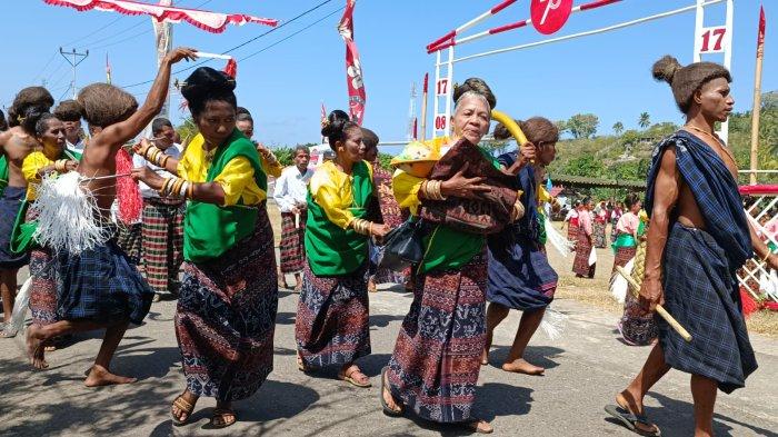FESTIVAL TOJA ME - Suasana Festival Toja Me di Lela, Sikka, Flores, NTT, Jumat 25 Agustus 2023. Tampak seorang ibu sedang menggendong duplikat Bayi diringi tarian dan gong gendang.