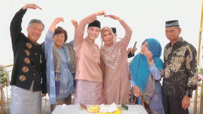 kedua keluarga berfoto bersama dengan mempelai