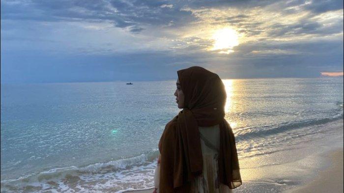 Annisa Tahir tengah menikmati keindahan langit senja di Pantai Kaisomaru, Minggu (1/12/24).