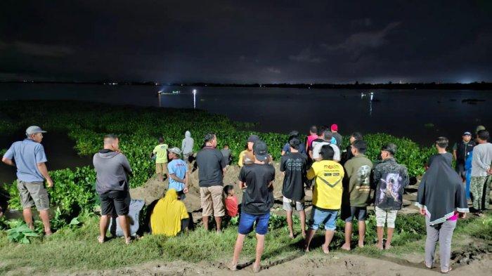 Masyarakat setempat menyaksikan pencarian korban tenggelam di Danau Limboto, Minggu (5/1/2025).