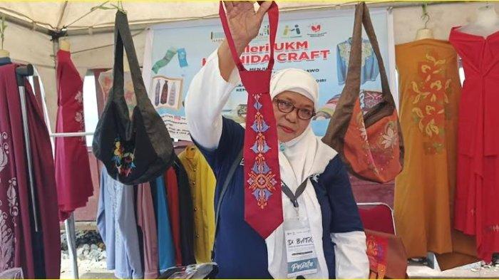 Pengrajin karawo Gorontalo, Harnida Mustafa memperlihatkan produk dasi karawo. Dasi ini juga dibeli oleh Menparekraf Sandiaga Uno saat berkunjung ke Molotabu Beach, Kecamatan Kabila Bone, Bone Bolango, Minggu (23/6/2024).