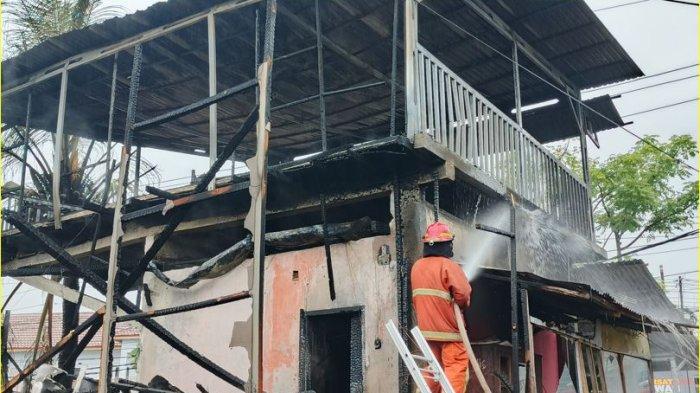 Petugas Damkar Kota Gorontalo tengah memadamkan sisa kebakaran di bangunan warkop di Jalan Sultan Botutihe, Kelurahan Heledulaa Selatan, Kecamatan Kota Timur, Kota Gorontalo, Kamis, (22/8/2024).