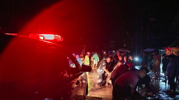 Warga Desa Huangobotu, Kabila Bone gotong royong membantu kendaraan melewati area jalan Trans Sulawesi, Senin (21/10/2024).