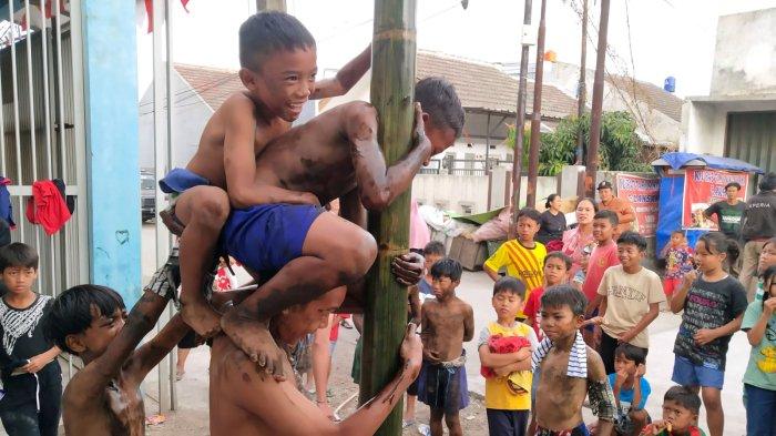 Sejumlah anak mengikuti lomba panjat pinang di RW 15, Desa Cangkuang Kulon, Kecamatan Dayeuhkolot, Kabupaten Bandung, Jawa Barat, Kamis (17/8/2023).