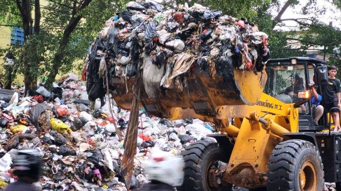 Petugas menggunakan alat berat loader memuat sampah untuk dimasukan ke dump truck dari area sampah yang menggunung di Tempat Pembuangan Sementara (TPS) tegallega, Jalan Moch. Toha, Kota Bandung, Jawa Barat, Kamis (12/10/2023).