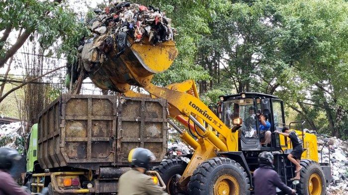Petugas menggunakan alat berat loader memasukan sampah ke dump truck dari area sampah yang menggunung di Tempat Pembuangan Sementara (TPS) tegallega, Jalan Moch. Toha, Kota Bandung, Jawa Barat, Kamis (12/10/2023).