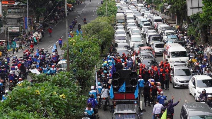 Massa buruh berjalan, naik mobil dan mengendarai sepeda motor dari Gedung Sate menuju Gerbang Tol Pasteur untuk melakukan blokade, melintas di Jalan Dr Djundjunan, Kota Bandung, Jawa Barat, Kamis (30/11/2023). Sementara sebagian massa buruh lainnya nekat melawan arah hingga membuat arus lalu lintas macet.