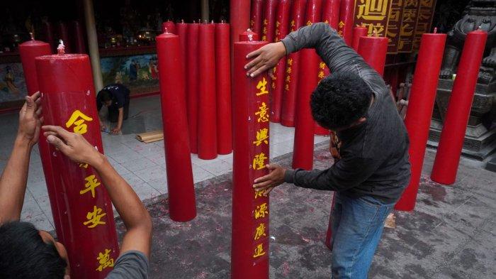Pekerja memasang stiker huruf China berisi doa-doa saat finishing pembuatan lilin merah untuk perayaan Tahun Baru Imlek di Vihara Dharma Ramsi, Gang Ibu Aisah, Jalan Cibadak, Kota Bandung, Jawa Barat, Rabu (10/1/2024).