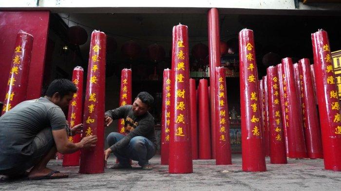 Pekerja memasang stiker huruf China berisi doa-doa saat finishing pembuatan lilin merah untuk perayaan Tahun Baru Imlek di Vihara Dharma Ramsi, Gang Ibu Aisah, Jalan Cibadak, Kota Bandung, Jawa Barat, Rabu (10/1/2024).
