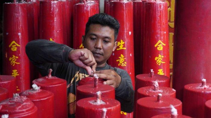 Pekerja merapikan sumbu saat finishing pembuatan lilin merah untuk perayaan Tahun Baru Imlek di Vihara Dharma Ramsi, Gang Ibu Aisah, Jalan Cibadak, Kota Bandung, Jawa Barat, Rabu (10/1/2024).