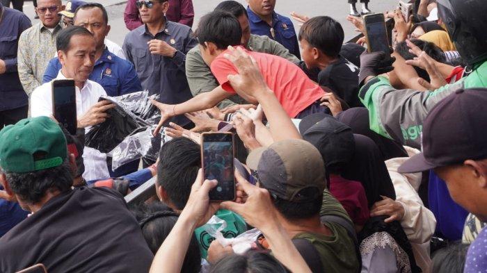 Presiden Joko Widodo (Jokowi) bagi-bagi kaus kepada warga seusai meresmikan Revitalisasi Terminal Leuwipanjang dan Terminal Banjar, di Terminal Leuwipanjang, Kota Bandung, Jawa Barat, Sabtu (3/2/2024).