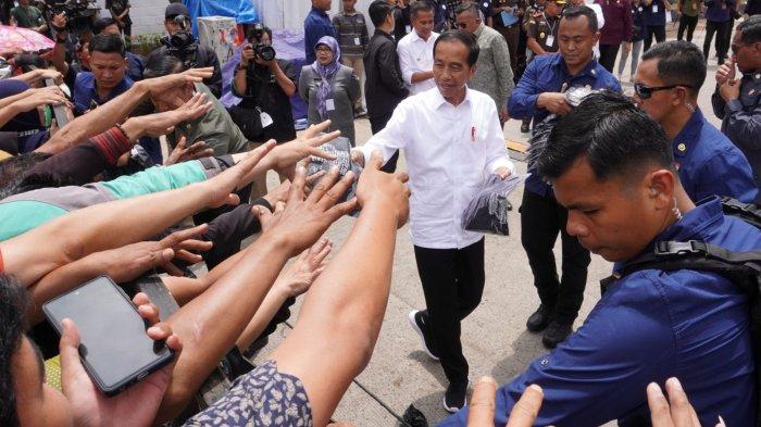 Presiden Joko Widodo (Jokowi) bagi-bagi kaus kepada warga seusai meresmikan Revitalisasi Terminal Leuwipanjang dan Terminal Banjar, di Terminal Leuwipanjang, Kota Bandung, Jawa Barat, Sabtu (3/2/2024).