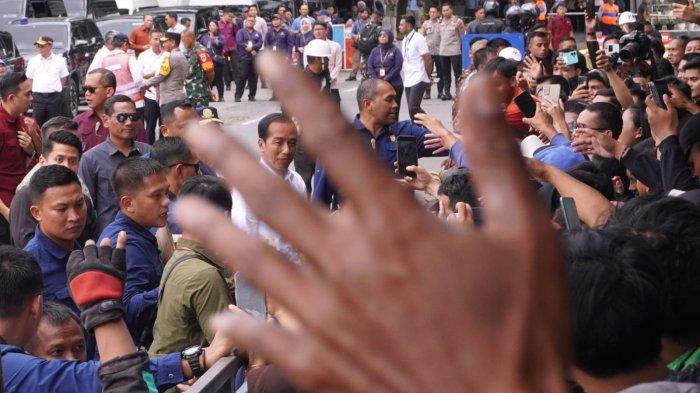 Presiden Joko Widodo (Jokowi) bagi-bagi kaus kepada warga seusai meresmikan Revitalisasi Terminal Leuwipanjang dan Terminal Banjar, di Terminal Leuwipanjang, Kota Bandung, Jawa Barat, Sabtu (3/2/2024).