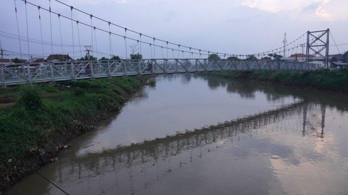 Kendaraan sepeda motor melintas di jembatan gantung yang melintang di Sungai Citarum, Desa Rancamanyar, Kecamatan Baleendah, Kabupaten Bandung, Jawa Barat, Senin (12/2/2024).