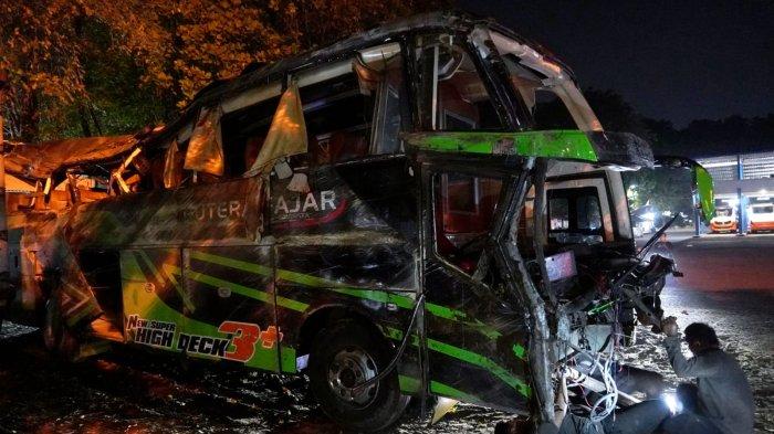 Petugas derek memarkirkan bangkai bus Putera Fajar nopol AD 7524 OG di Terminal Subang pasca kecelakaan maut yang membawa rombongan pelajar SMK Lingga Kencana Depok, di Jalan Raya Ciater, Kampung/Desa Palasari, Kecamatan Ciater, Kabupaten Subang, Jawa Barat, Sabtu (11/5/2024) malam.