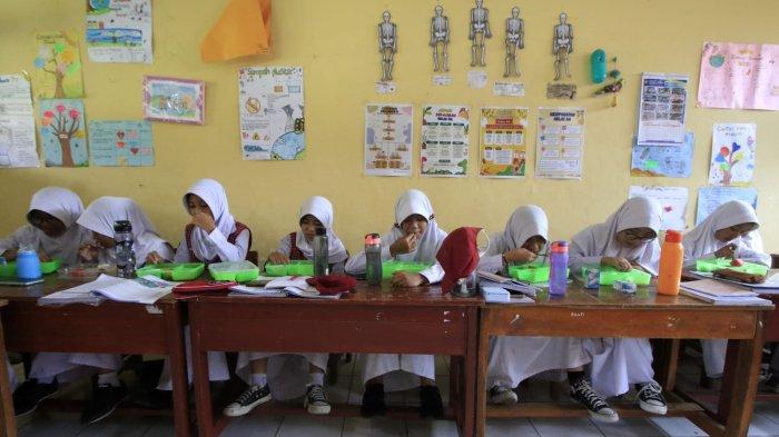 Sejumlah siswa menyantap makanan bergizi gratis saat jam istirahat di SDN 173 Neglasari, Kelurahan Sadangserang, Kecamatan Coblong, Kota Bandung, Jawa Barat, Senin (25/11/2024).