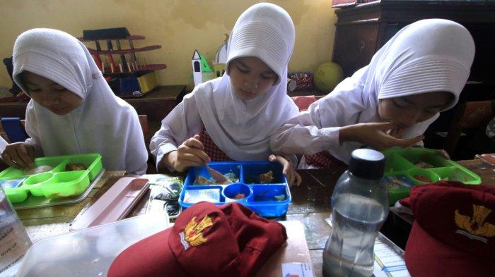 Sejumlah siswa menyantap makanan bergizi gratis saat jam istirahat di SDN 173 Neglasari, Kelurahan Sadangserang, Kecamatan Coblong, Kota Bandung, Jawa Barat, Senin (25/11/2024).