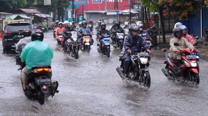 Pemotor berangkat kerja menggunakan jas hujan di saat hujan rintik-rintik, melintas di Jalan Raya Dayeuhkolot, Kecamatan Dayeuhkolot, Kabupaten Bandung, Jawa Barat, Rabu (4/12/2024).