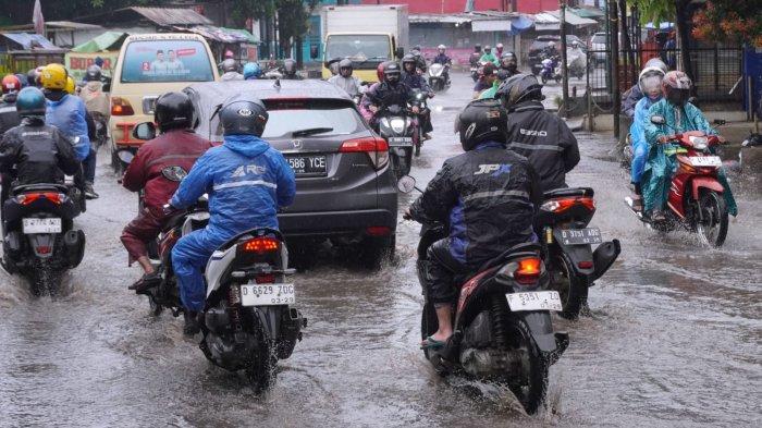 Pemotor berangkat kerja menggunakan jas hujan di saat hujan rintik-rintik, melintas di Jalan Raya Dayeuhkolot, Kecamatan Dayeuhkolot, Kabupaten Bandung, Jawa Barat, Rabu (4/12/2024).