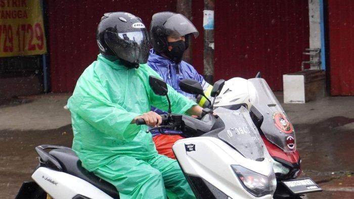 Pemotor berangkat kerja menggunakan jas hujan di saat hujan rintik-rintik, melintas di Jalan Raya Dayeuhkolot, Kecamatan Dayeuhkolot, Kabupaten Bandung, Jawa Barat, Rabu (4/12/2024).