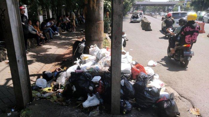 Pengguna jalan melintasi sampah yang menumpuk di pinggir jalan depan Rumah Sakit Hasan Sadikin (RSHS), Jalan Pasirkaliki, Kota Bandung, Jawa Barat, Selasa (7/1/2025).