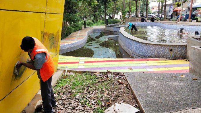 Warga membersihkan cat semprot di dinding bangunan toilet di Taman Alun-Alun Regol, Kelurahan Sukaluyu, Kecamatan Regol, Kota Bandung, Jawa Barat, Kamis (17/4/2025).