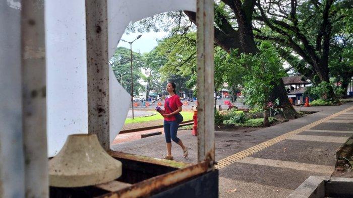 Warga melintas di samping lampu penerangan yang rusak, di Saparua Park, Kelurahan Citarum, Kecamatan Bandung Wetan, Kota Bandung, Jawa Barat, Sabtu (19/4/2025).
