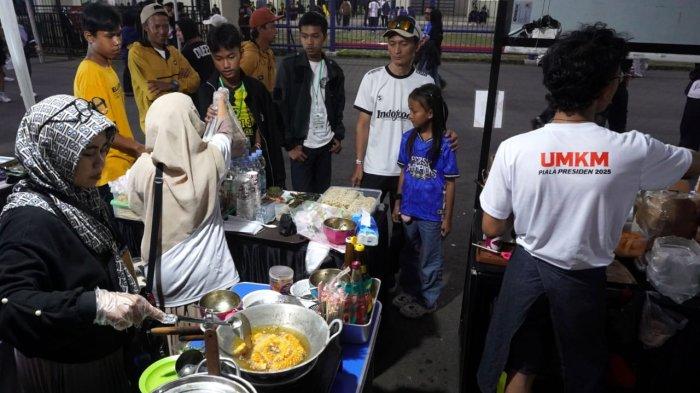 Suporter membeli jajanan di stand UMKM sebelum menyaksikan pertandingan Persib Bandung melawan Dewa United pada gelaran Piala Presiden 2025, di Stadion Si Jalak Harupat, Soreang, Kabupaten Bandung, Jawa Barat, Selasa (8/7/2025).
