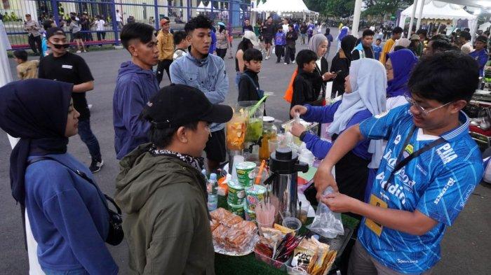 Suporter membeli jajanan di stand UMKM sebelum menyaksikan pertandingan Persib Bandung melawan Dewa United pada gelaran Piala Presiden 2025, di Stadion Si Jalak Harupat, Soreang, Kabupaten Bandung, Jawa Barat, Selasa (8/7/2025).