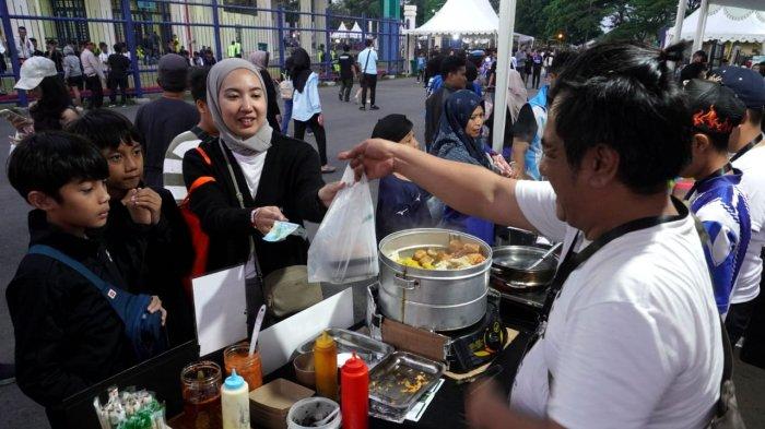 Suporter membeli jajanan di stand UMKM sebelum menyaksikan pertandingan Persib Bandung melawan Dewa United pada gelaran Piala Presiden 2025, di Stadion Si Jalak Harupat, Soreang, Kabupaten Bandung, Jawa Barat, Selasa (8/7/2025).