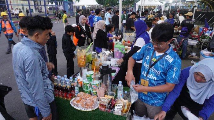 Suporter membeli jajanan di stand UMKM sebelum menyaksikan pertandingan Persib Bandung melawan Dewa United pada gelaran Piala Presiden 2025, di Stadion Si Jalak Harupat, Soreang, Kabupaten Bandung, Jawa Barat, Selasa (8/7/2025).