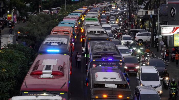 Iring-iringan bus pariwisata yang mengangkut pelaku usaha pariwisata memperlambat perjalanan pulang di Jalan Dr Djunjunan usai menggelar aksi unjuk rasa di depan Gedung Sate, Jalan Diponegoro, Kota Bandung, Jawa Barat, Senin (21/7/2025).mereka tumpangi usai menggelar aksi unjuk rasa di depan Gedung Sate, Jalan Diponegoro, Kota Bandung, Jawa Barat, Senin (21/7/2025).